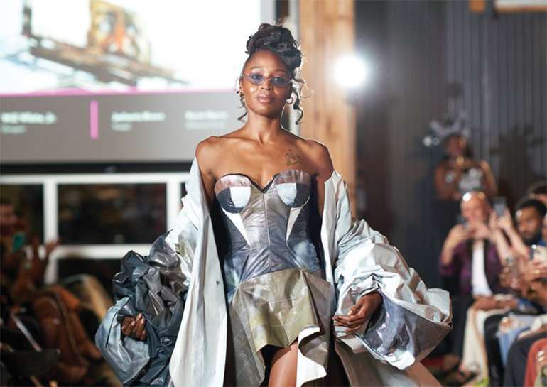 Model walking in a metallic dress on runway