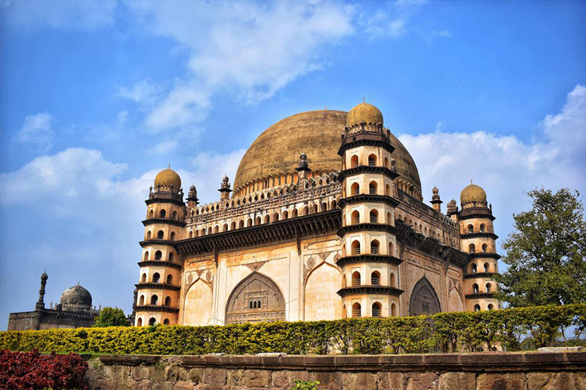 Gol Gumbaz mausoleum under a clear blue sky.