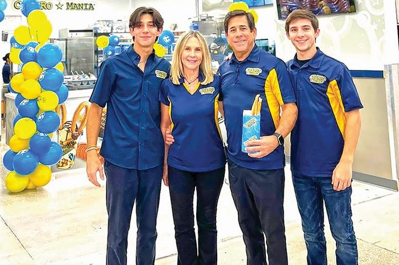 Family at churro store with balloons.