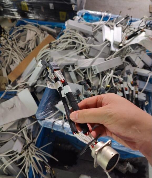Hand holding electronic cables from a pile.