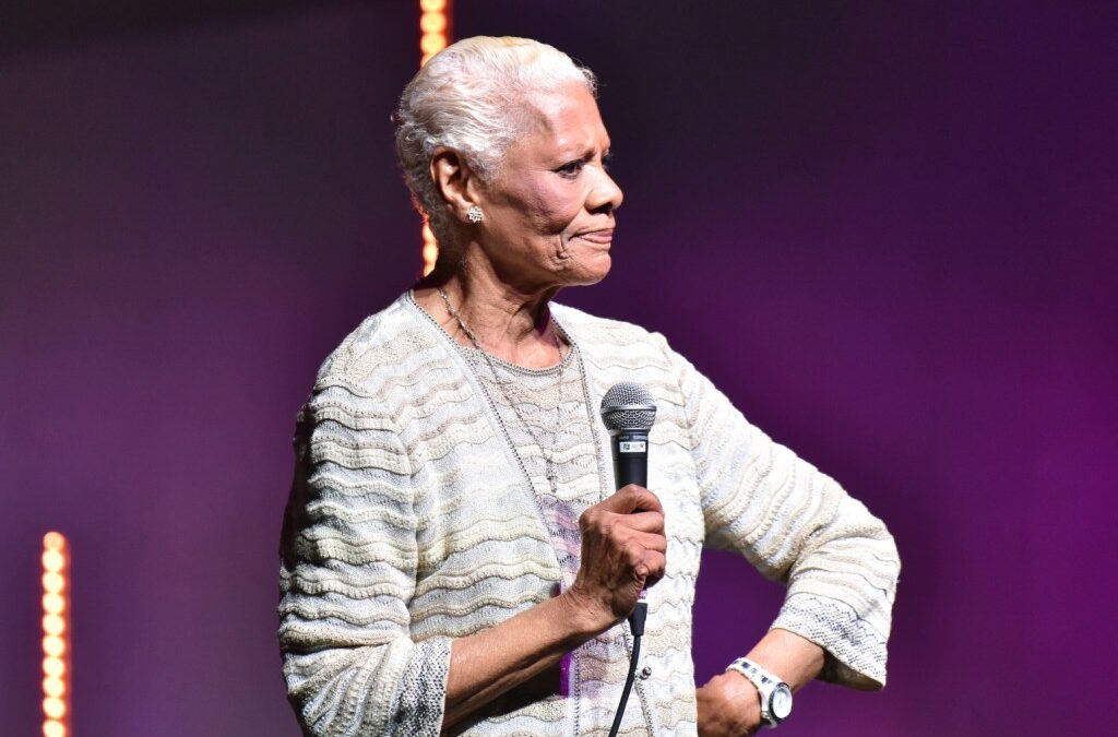 Elderly woman holding a microphone on stage