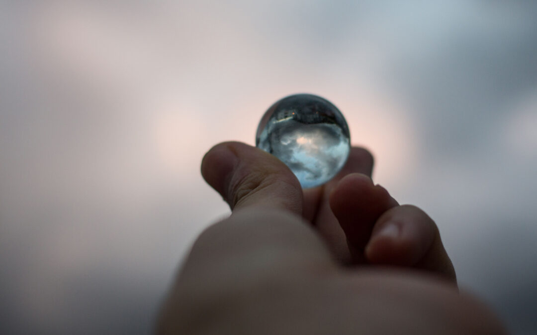 Hand holding a reflective glass sphere