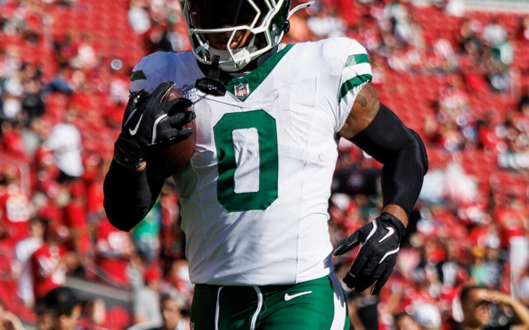 Football player in white and green jersey running