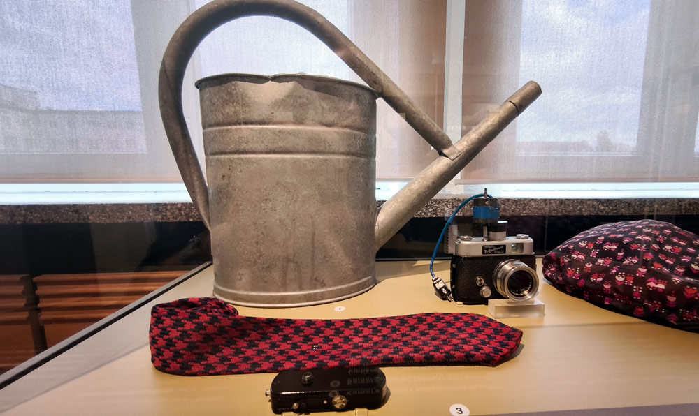 Vintage watering can, camera, tie on display.