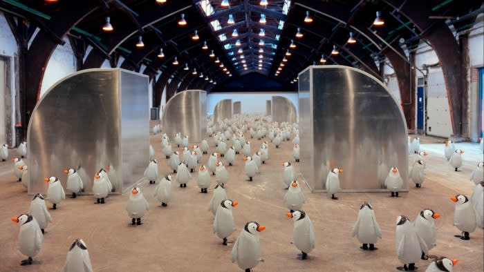 Penguins in an art installation inside a large hall.
