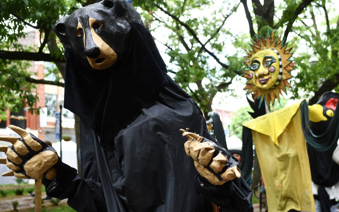 Giant bear and sun costumes at outdoor festival