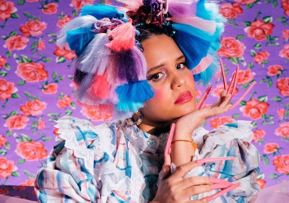 Colorful fashion portrait with dramatic nails and flowers.
