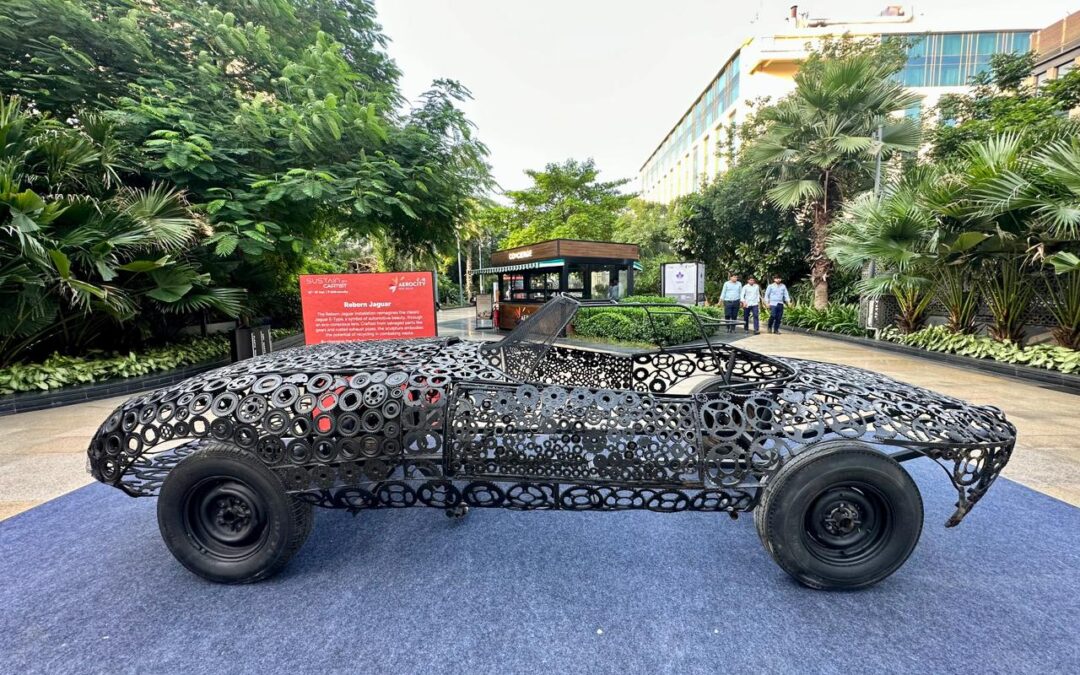 Sculptural car made from recycled metal parts outdoors.