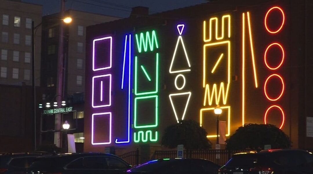 Colorful neon geometric shapes on building facade.