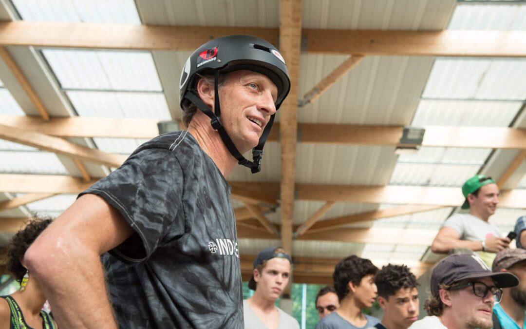 Man wearing helmet at indoor skate park gathering.