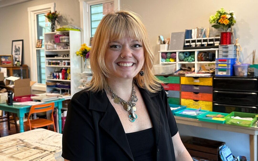 Woman smiling in colorful craft room.