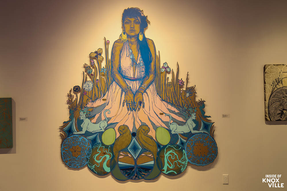 Colorful wall mural of a seated woman with flowers.