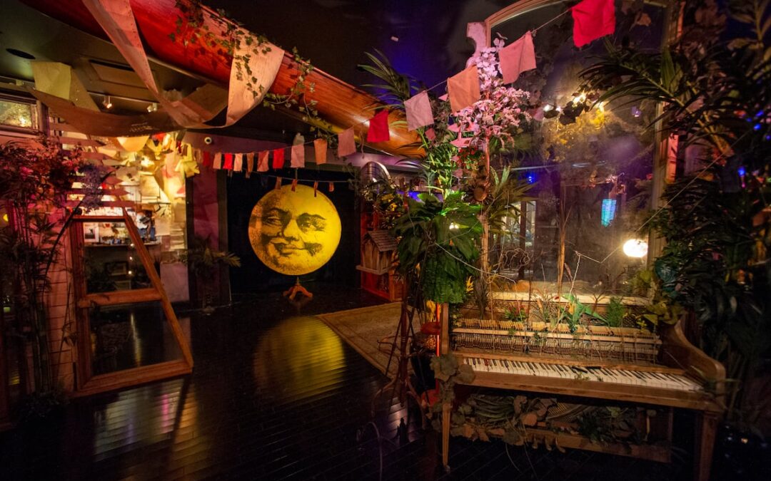 Whimsical room with moon art and hanging flags.