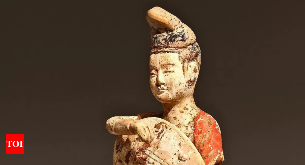 Ancient Chinese painted pottery figurine with hat and drum.