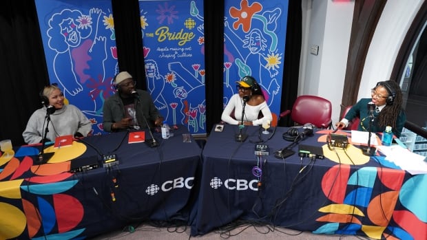 Podcast hosts recording in vibrant studio setting.