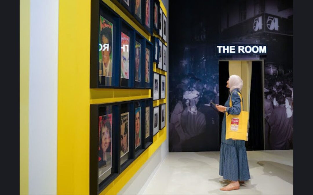 Woman explores art gallery exhibition, yellow wall highlights portraits.
