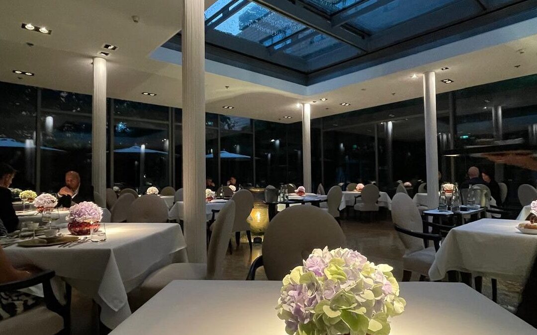 Elegant restaurant interior with dim lighting and flowers.