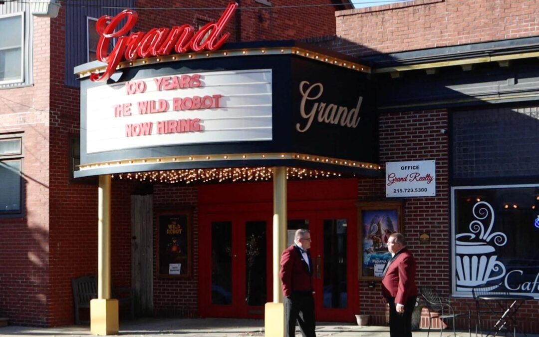 Theater entrance with marquee displaying show titles.