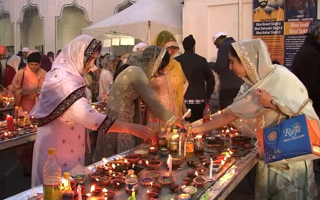 Women lighting candles at a cultural event.