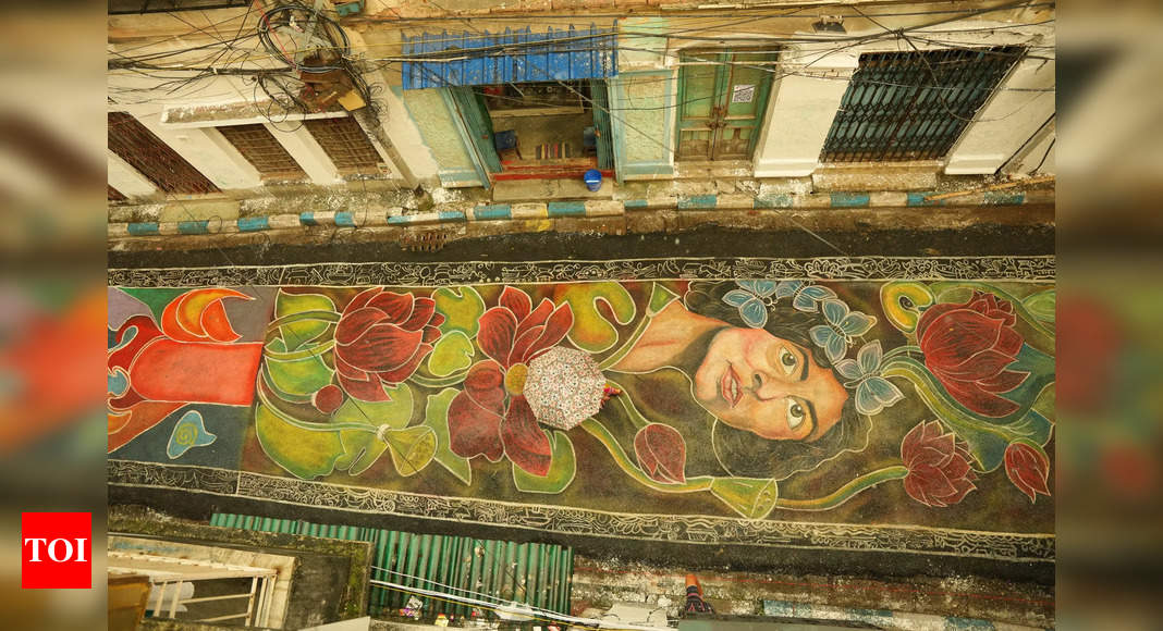 Colorful street mural of a woman's face and flowers.