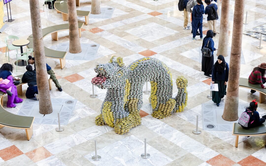 Canned food sculpture of an animal in a mall.