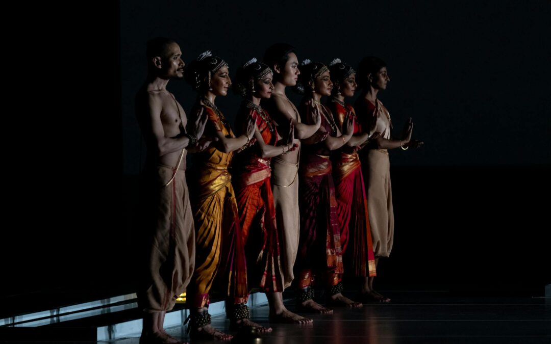 Traditional dancers perform on stage in colorful attire.