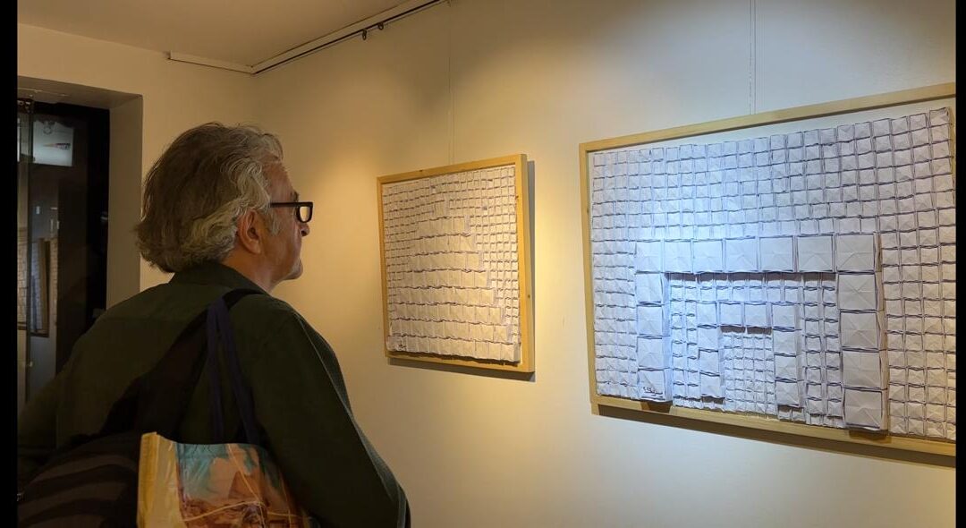 Person observing abstract art installation in gallery.