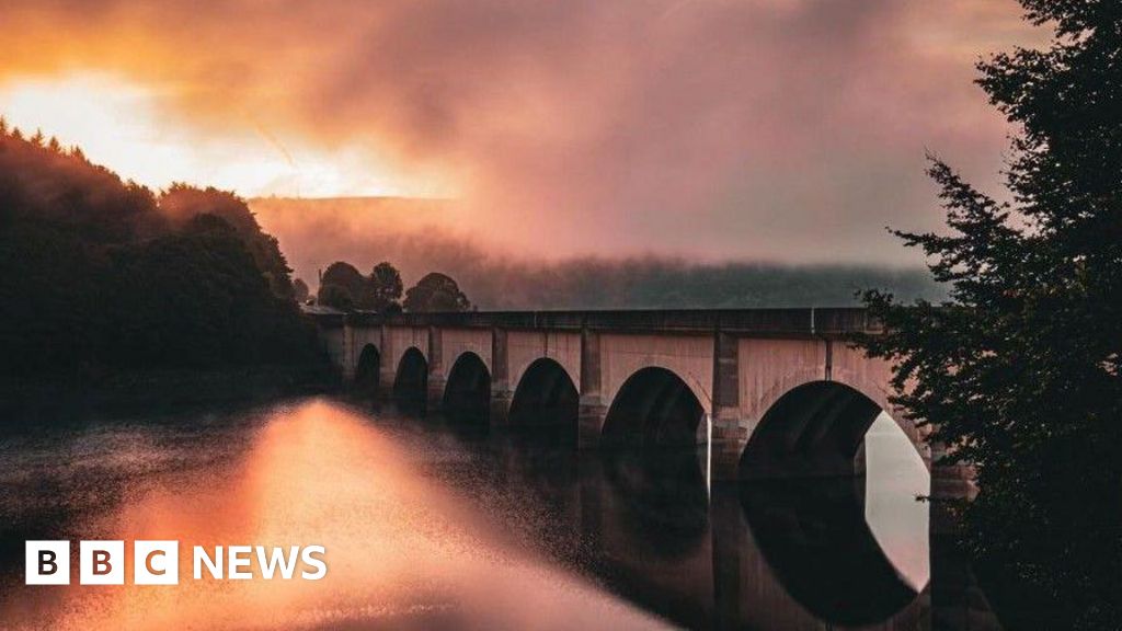 Foggy sunrise over reservoir and bridge