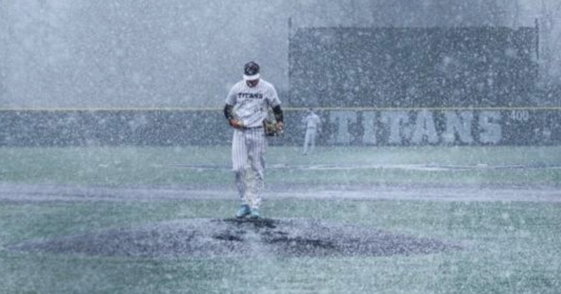 Baseball player in snow on field, Titans team