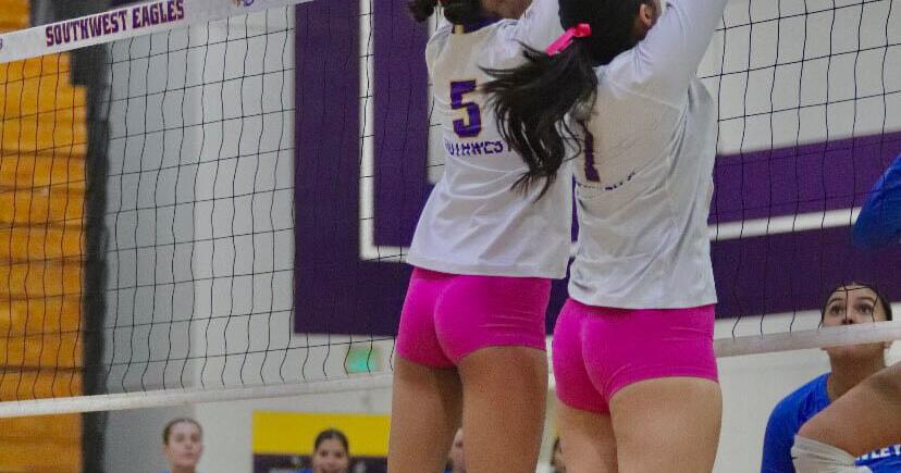 Volleyball players jumping to block at net.