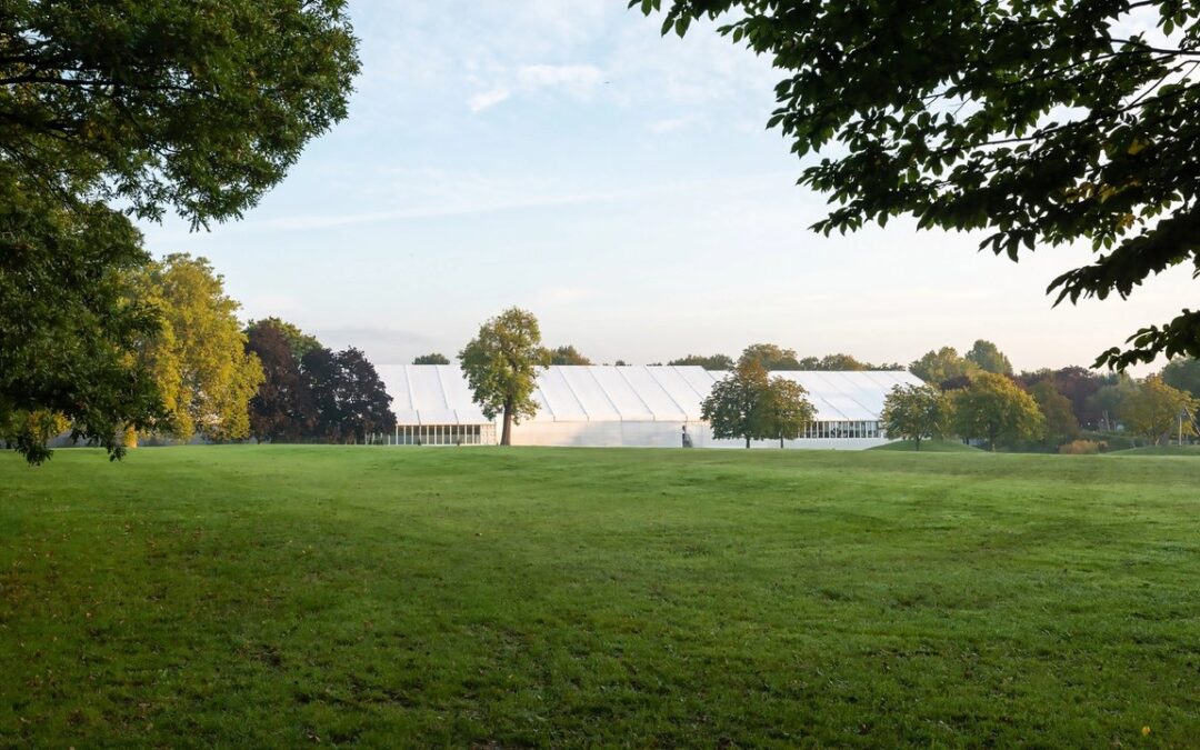 White tent in a large green park
