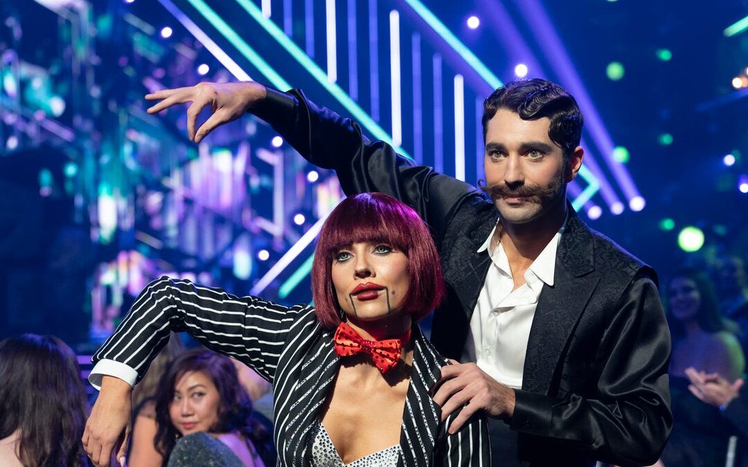 Dancers in unique costumes perform on stage.