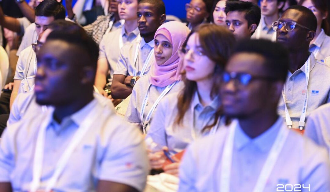 Diverse audience at a conference, wearing lanyards.