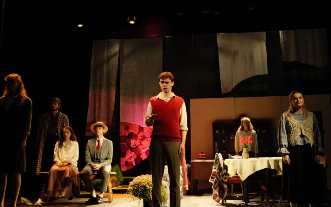Actors performing on a dimly lit stage scene.
