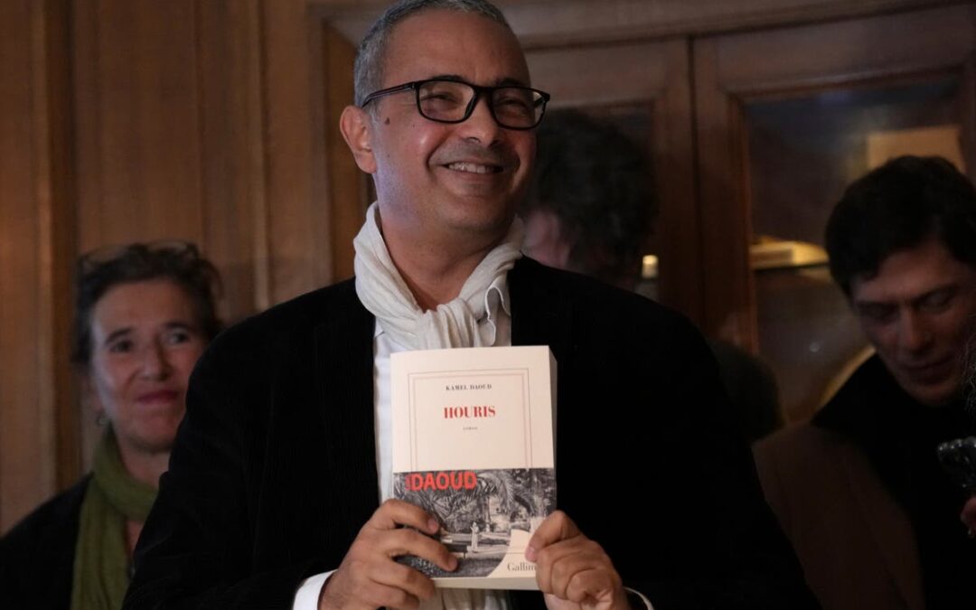 Person smiling, holding a book titled 'Houris'