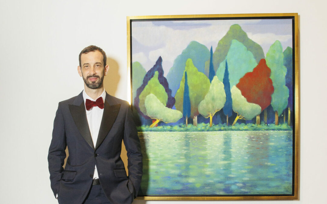 Man in suit beside landscape painting
