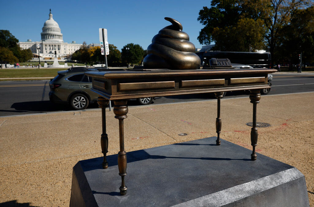 Capitol building with unusual sculpture on pedestal.