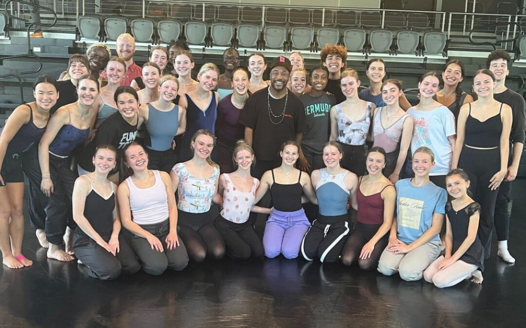 Large group of dancers posing together in studio.