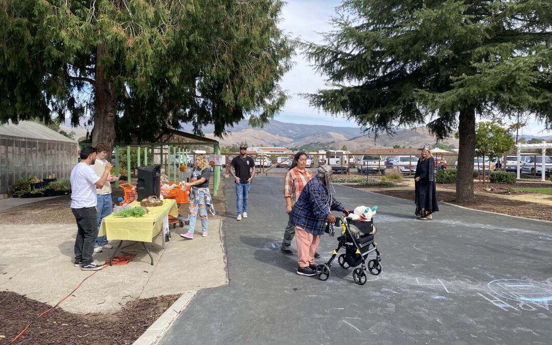 Community gathering in a park with food stand.