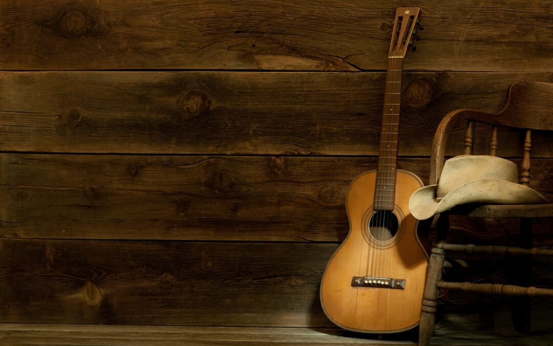 Guitar and cowboy hat on wooden chair