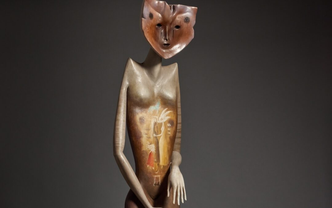 Abstract sculpture with intricate mask face design.