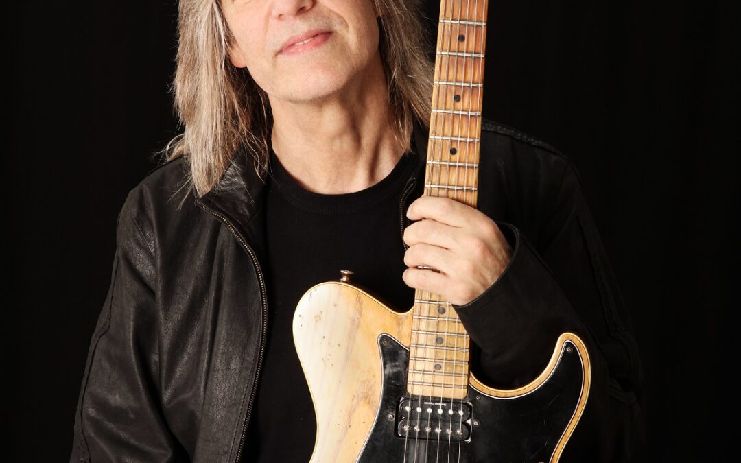 Person holding electric guitar, black background