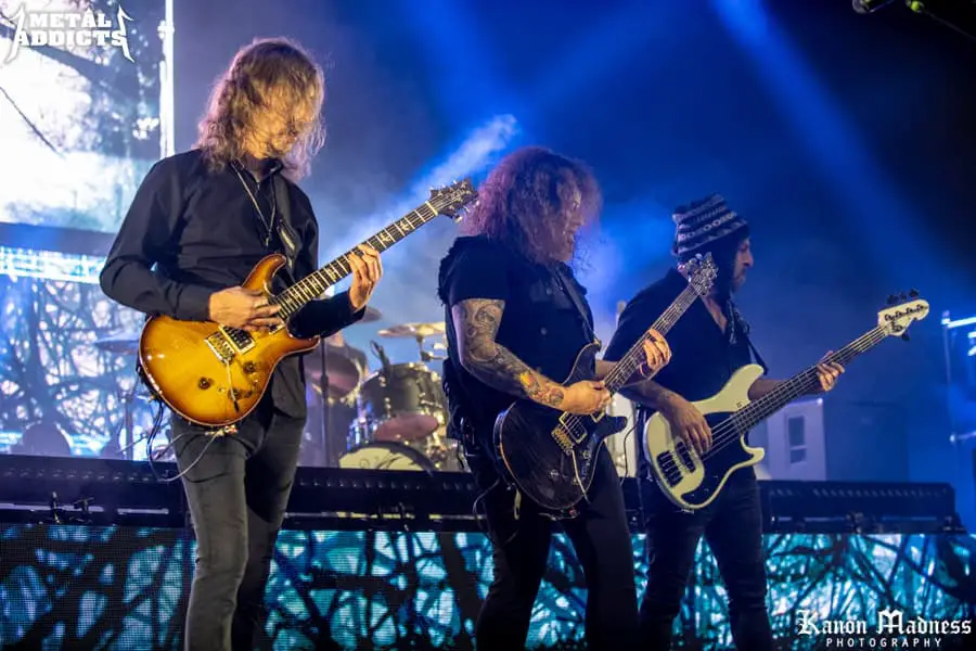 Rock band performing live on stage with guitars.