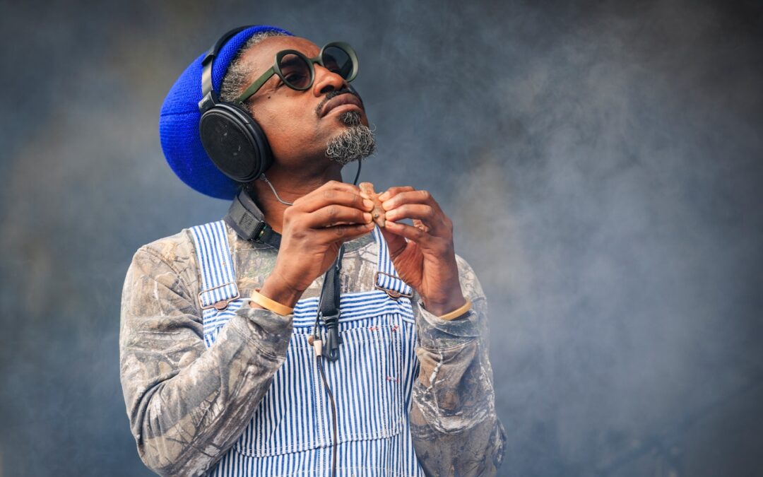 Man wearing headphones playing a wooden instrument