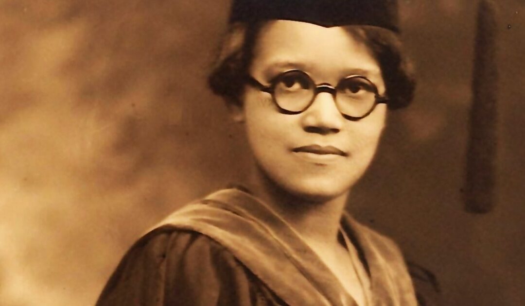 Graduate wearing cap and gown, vintage photo.