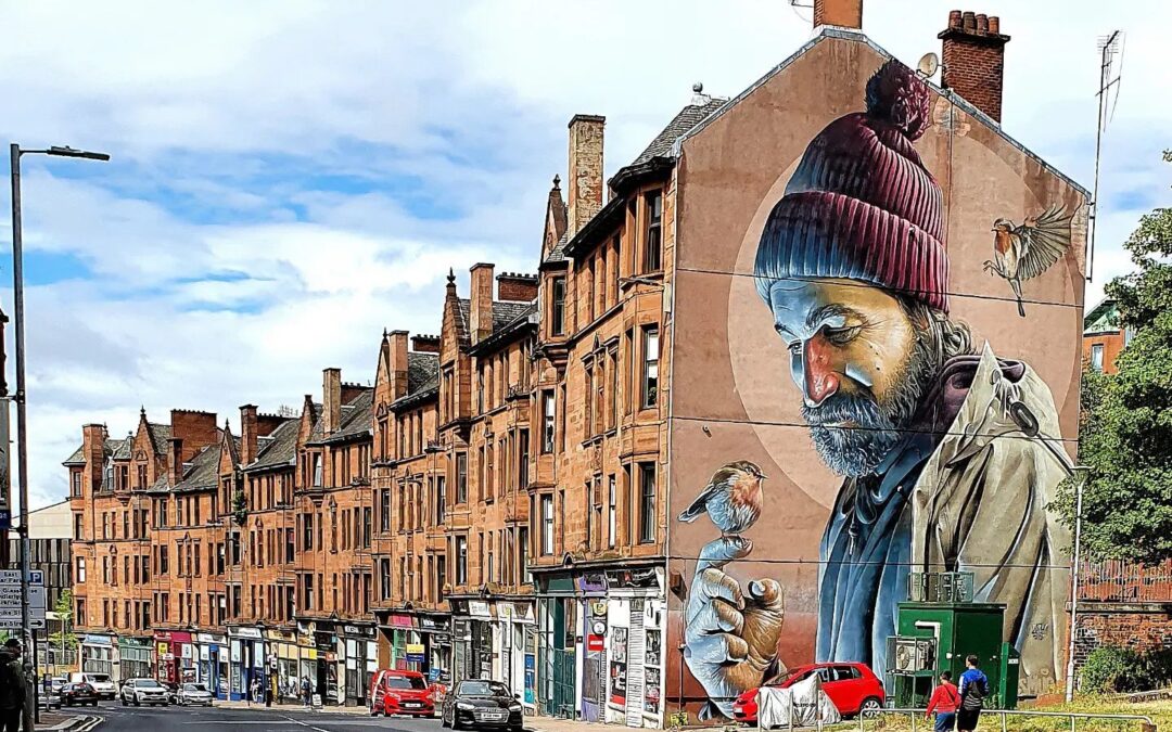 Street mural of man with birds in cityscape.