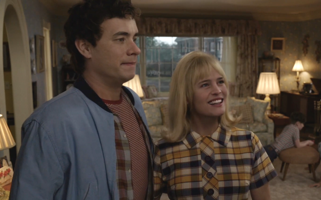 Couple smiling in retro living room setting.