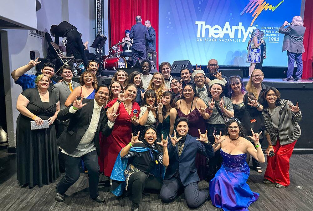 Group celebrating at theater event with smiles.