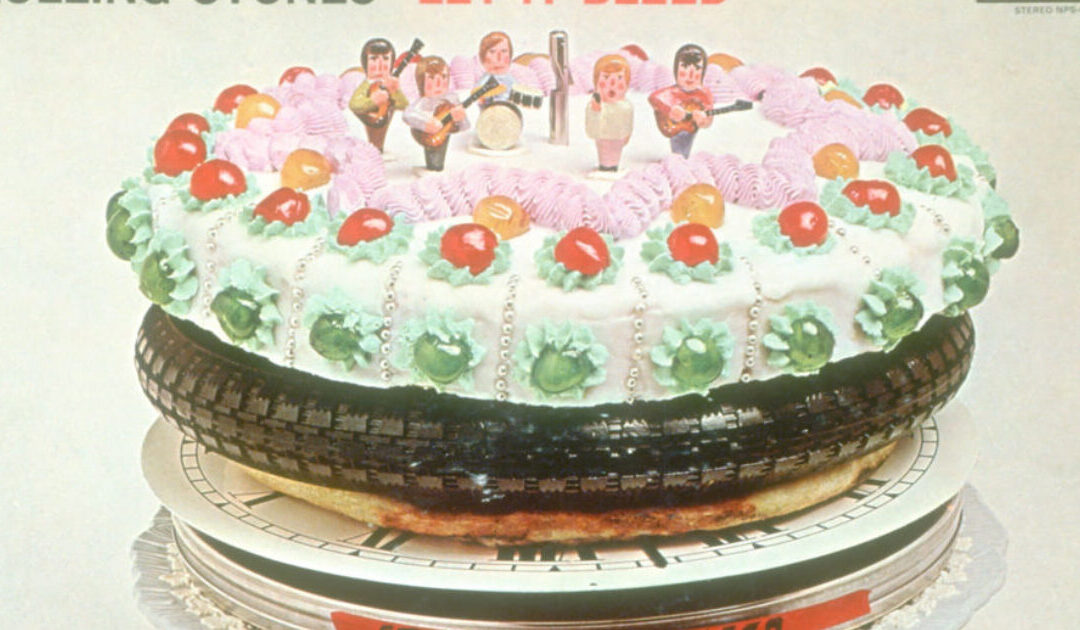 Cake with toy musicians on tire platform.