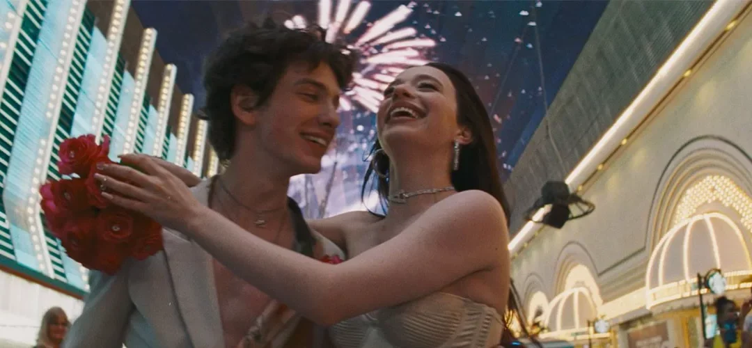 Couple laughing under colorful fireworks display.